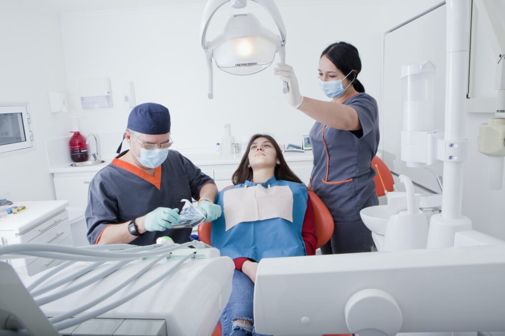 Dentist and dental nurse with patient